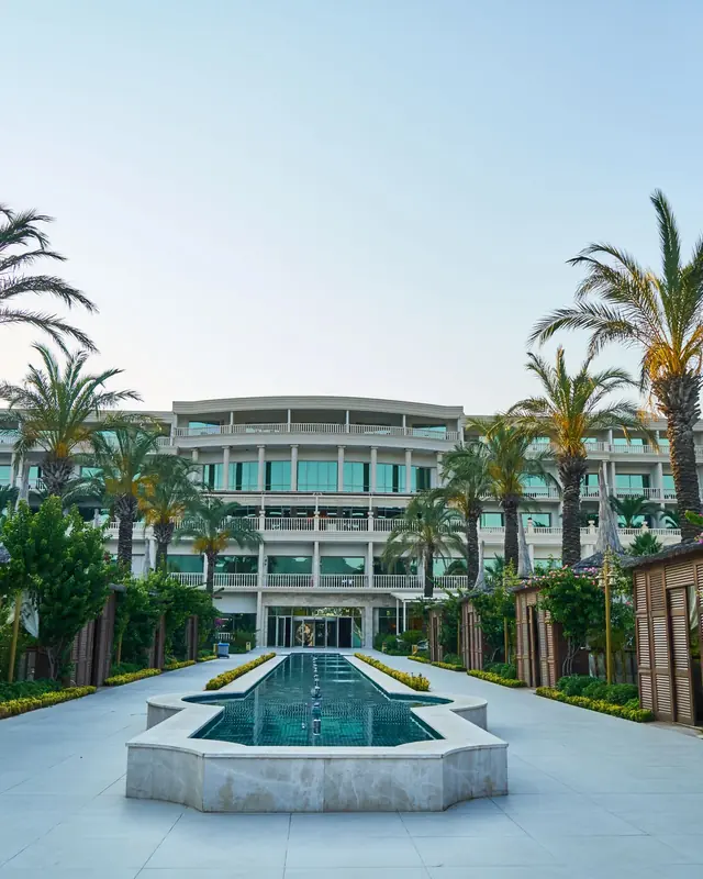 Resort courtyard with palm trees and a long reflecting pool